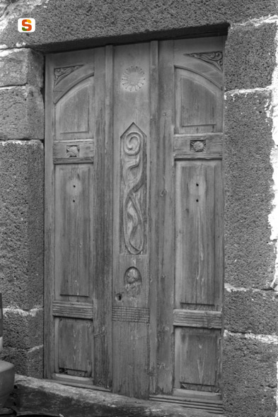 motivi decorativi vegetali// motivo decorativo a rosette// elementi decorativi antropomorfi (portone) (sec. XX)